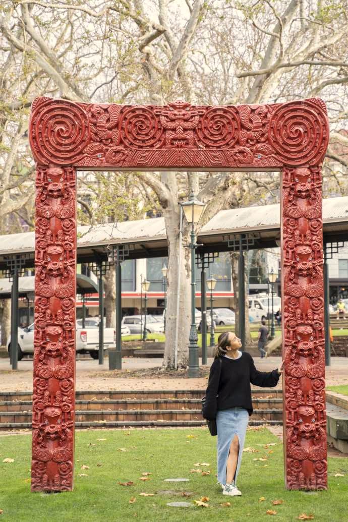 A young woman admires the Ko Te Tuhono gateway sculpture in the Octagon as she walks through it.
