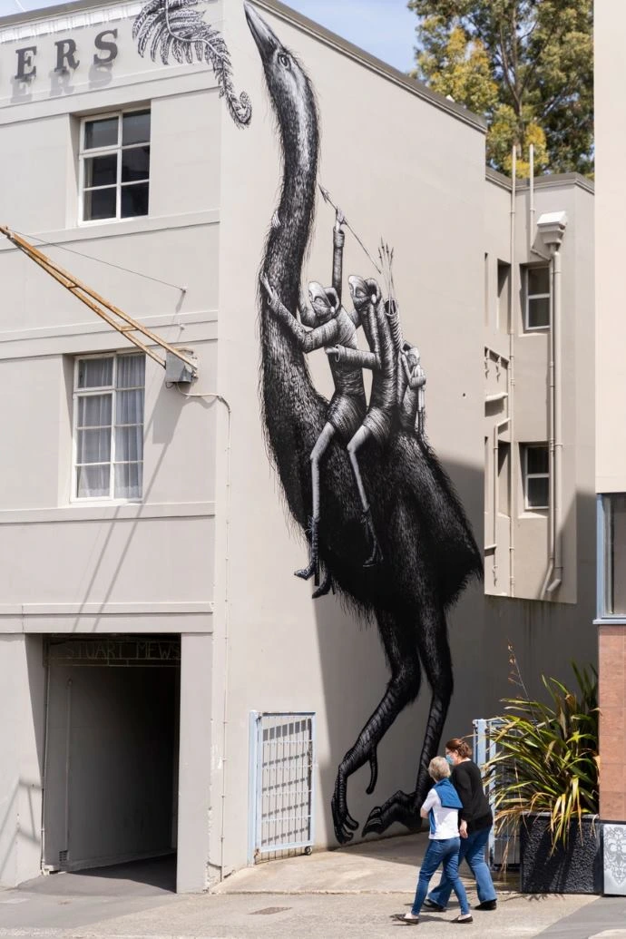 Street art by Phlegm depicts two creatures riding a moa.