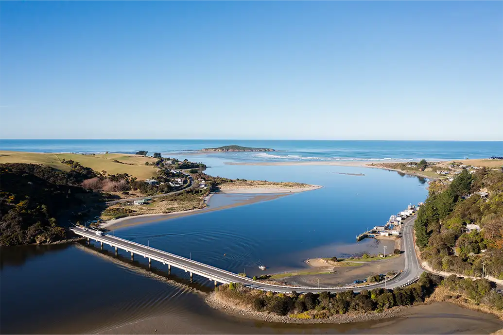 An aerial view of Taieri Mouth and the road bridge which spans the water. 