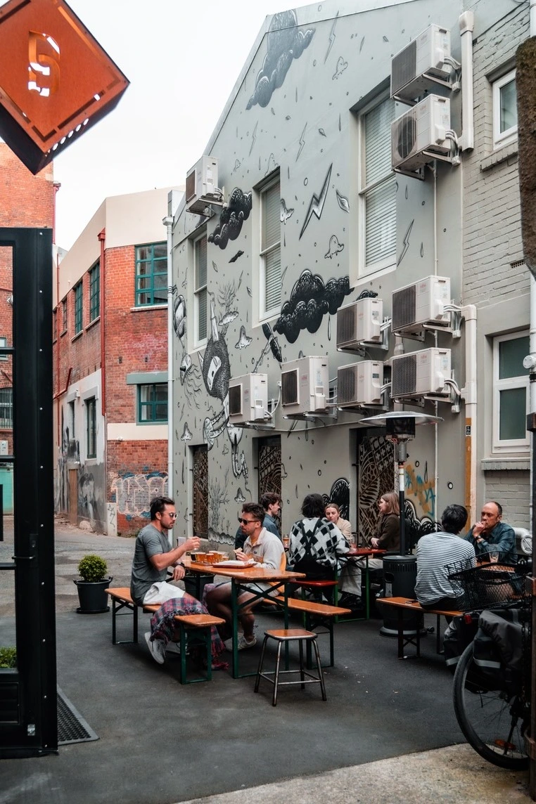 Street Art Trail Steamer Basin People enjoy al fresco beers in the courtyard of Steamer Basin Brewery in No Name Alley.